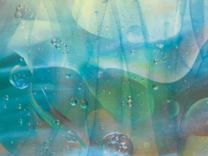 A textured overlay of soft hues of blue and green with layers of movement and dew drops.