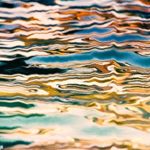 Rippled layers of teal, gold, and cream flows, creating a fluid abstract with dynamic movement.