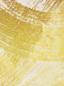Bold gold brushstrokes sweep across a neutral backdrop, creating a textured, modern composition.