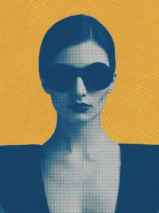 Bold portrait of a woman in sunglasses set against a vivid gold background.