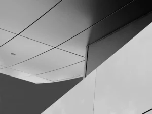 Minimalist architectural composition with sharp angles, smooth surfaces, and striking light contrast.