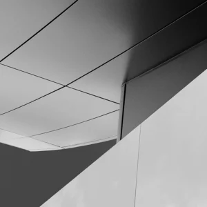 Minimalist architectural composition with sharp angles, smooth surfaces, and striking light contrast.