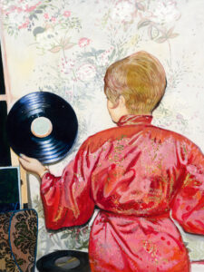 Golden light, floral walls, and vinyl’s gleam—nostalgia turns softly toward sound.