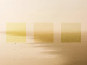 Muted seascape with three golden squares fades into soft, hazy horizon.
