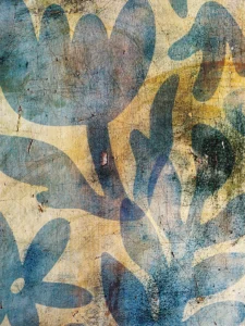 Weathered textures frame abstract blue florals, whispering nature’s resilience through time.