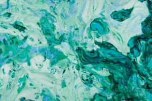 Vibrant green and teal patterns swirl across the surface, creating an impression of movement and depth. The flowing shapes and color play offer a sense of tranquility.