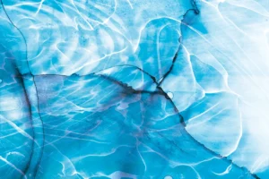 Shimmering blue water ripples over dark cracks forming in the foundation.