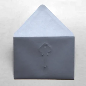 Minimalist gray envelope embossed with subtle cloud design against soft neutral background.