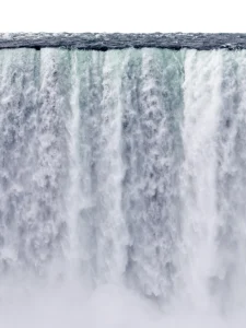 Powerful cascade of rushing water crashes downward, capturing nature’s immense force and motion.