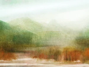 Frothy waves lap against amber forestry at the base of a misty mountain.