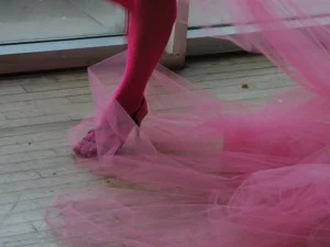 Pools of tule ensnare a fishnet-wearing, heeled foot, ready to spin atop a messy dancefloor.