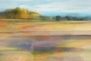 Hazy, sweeping view of an open land with a collection of buildings in the distance, nestled along a tree line.